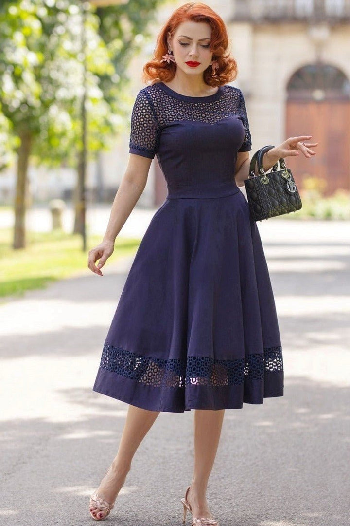 A charming model wearing a Tess Crochet Lace Formal Dress In Navy Blue