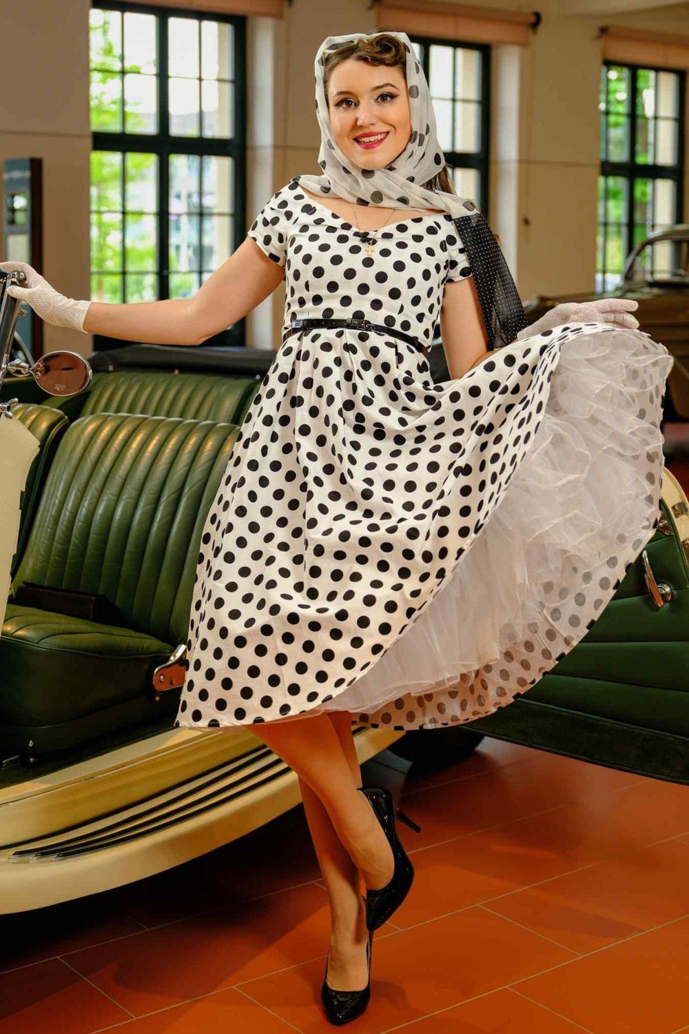 A lovely woman wearing a Lily Black Polka Dot Off Shoulder Dress In White