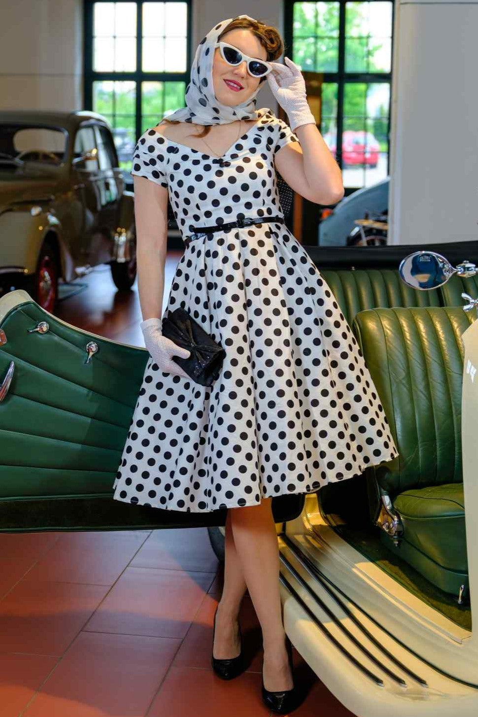 A model wearing a Lily Black Polka Dot Off Shoulder Dress In White