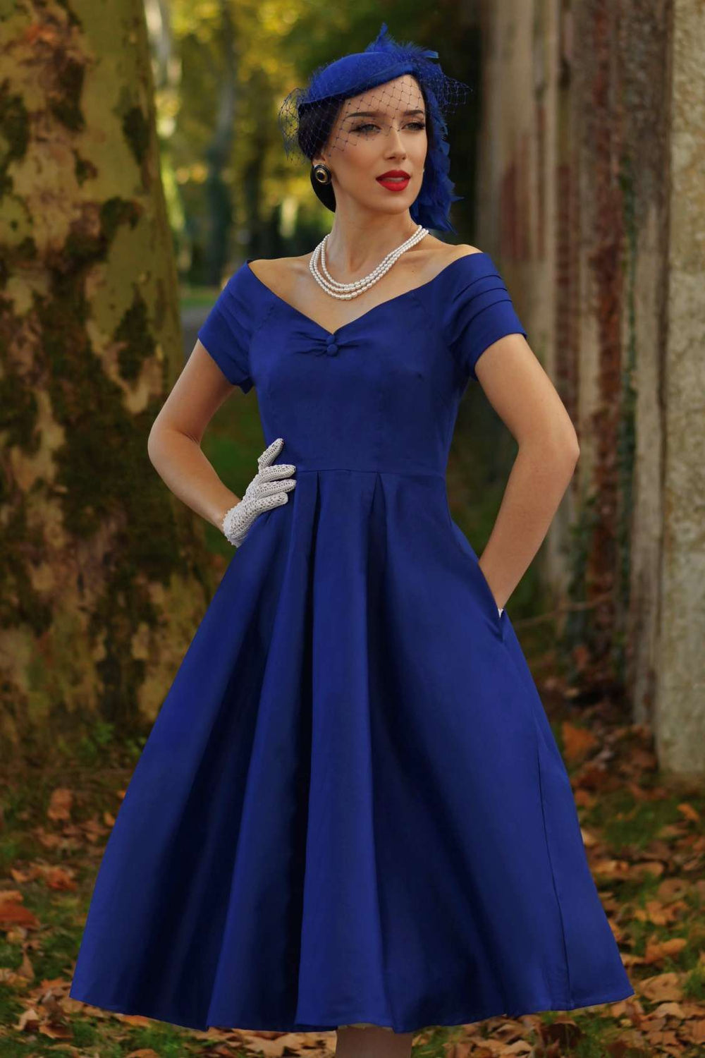 Close-up shot of a lovely model wearing a Lily Navy Bardot Midi Dress.