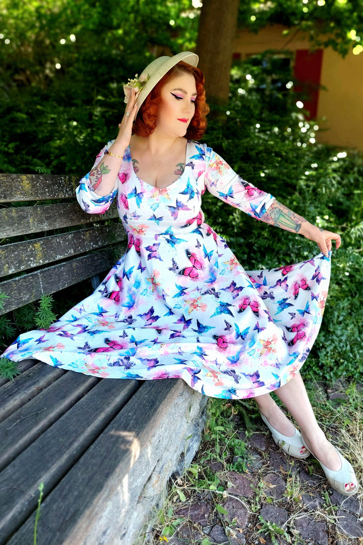 Lovely model wearing a Scarlette Midi Dress in White Butterfly Print