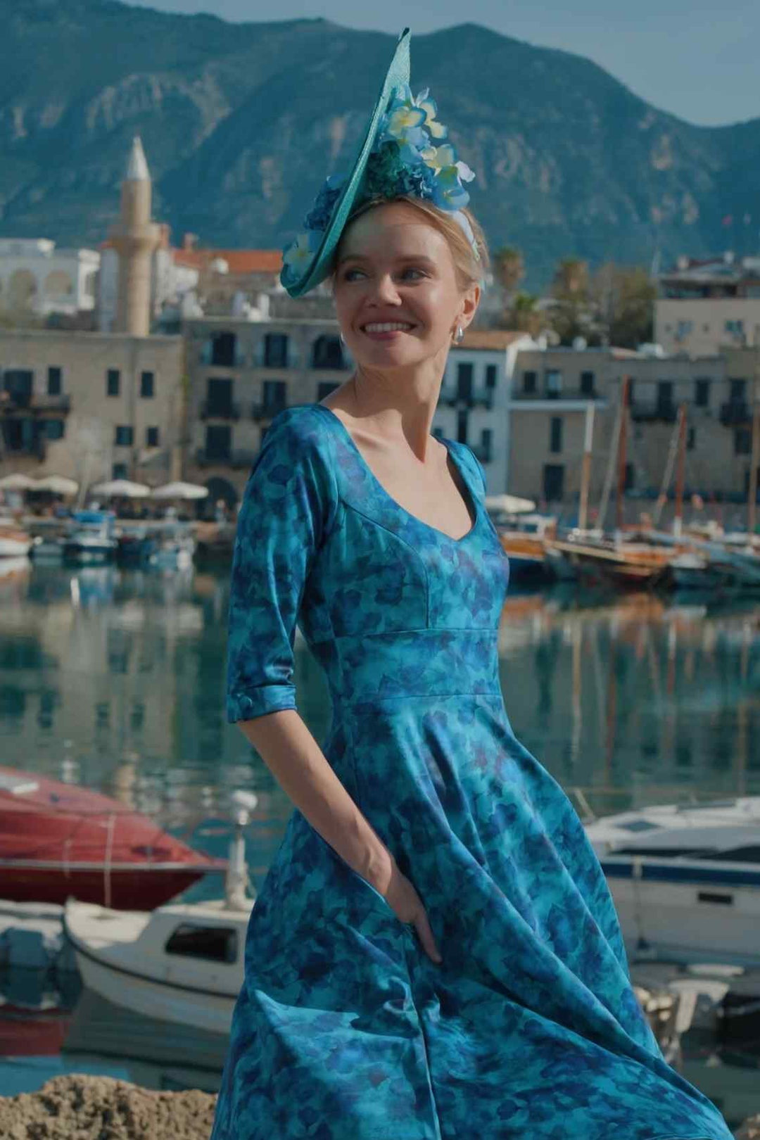 Close up shot of Model posing in Scarlette Blue Watercolour Floral Midi Dress stands by the coastal harbour