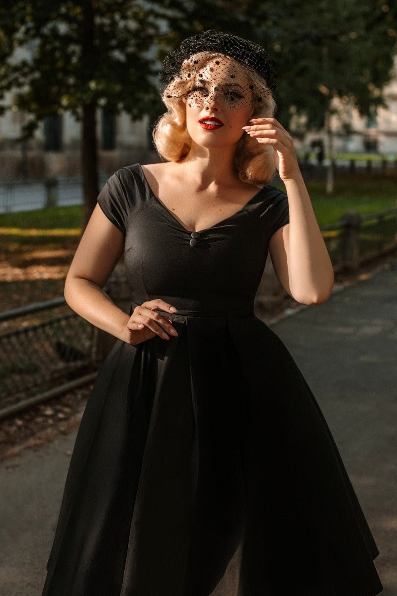 Model wearing a Lily Solid Black Off Shoulder Dress