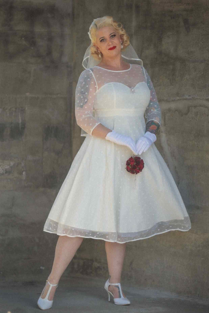 A lady wearing a Madeline Ivory White Polka Dot Dress